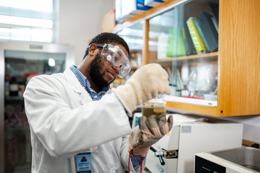 a student looks at a vial